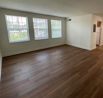 an empty living room with a hardwood floor