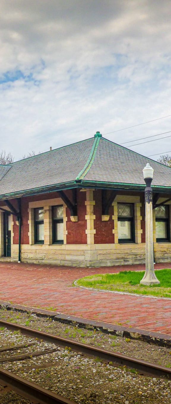 an old train station on a cloudy day with train tracks in front of it