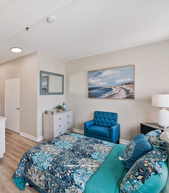 a bedroom with a bed and a microwave and a kitchen