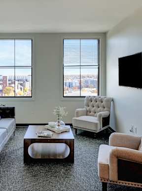 A living room with a couch, chair, and television at Parkhaus Apartments, Lincoln, Nebraska