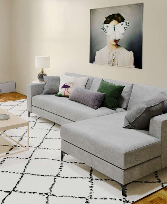 A living room with a white couch and a dining table.