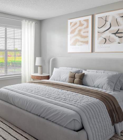 A bedroom with a large bed and two framed pictures on the wall.