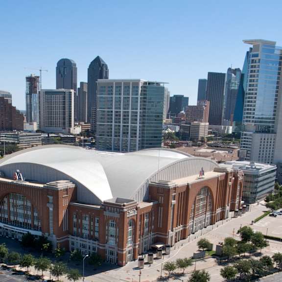 A large stadium with a dome-like roof is the focal point of the image, surrounded by a cityscape.