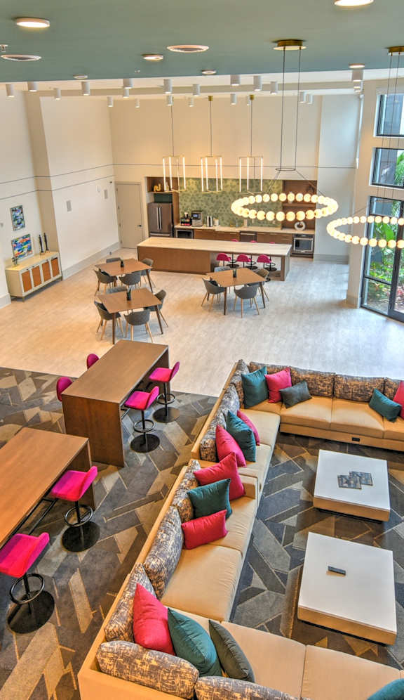 A large room with a lot of seating and a TV on the wall.