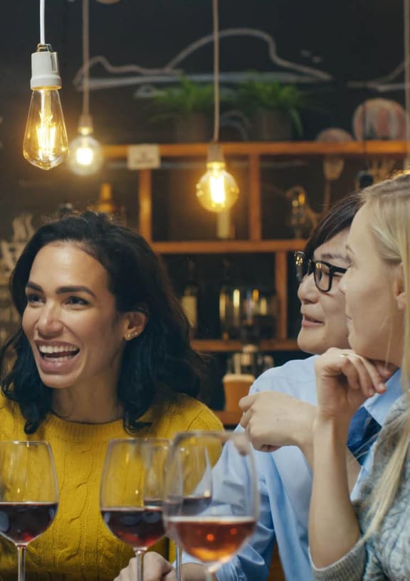 a group of people sitting around a table with wine glasses