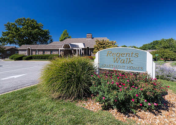 The entrance sign for Regent's Walk Apartment Homes, displayed in front of a landscaped area with greenery.