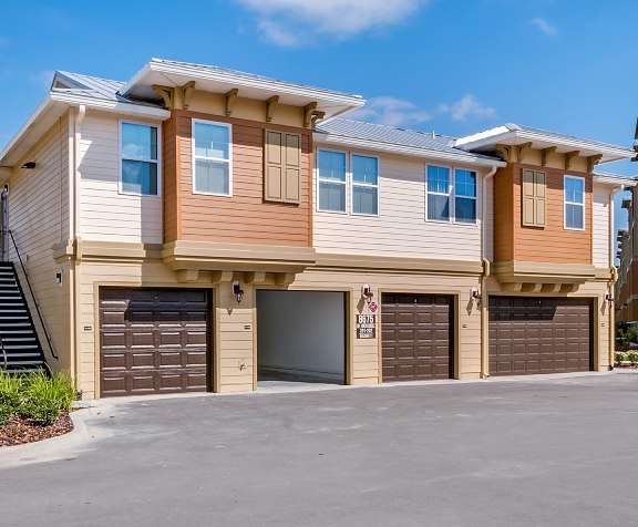 a driveway in front of a house with two garages
