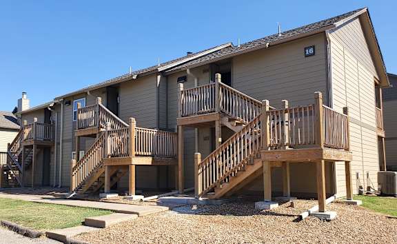 Willow Creek Apartments - A view of the apartment complex with green landscaping and walking paths.