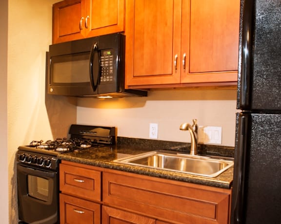 Lahaina Town Apartments kitchen area with appliances, cabinets, and counters