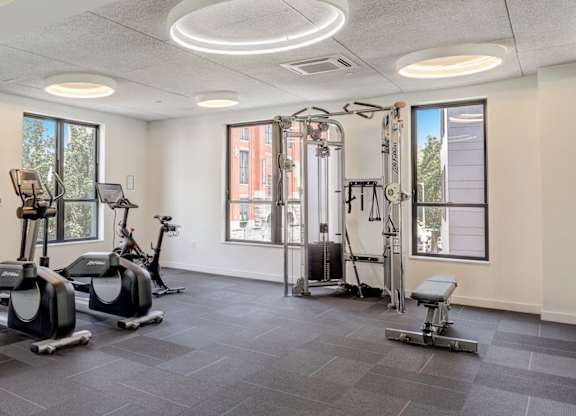Fitness center with cardio equipment and cable machine.