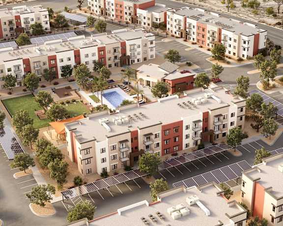 A bird's eye view of a residential complex with multiple buildings and a parking lot.