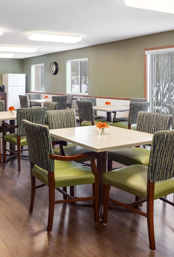 a dining room with tables and chairs and a kitchen