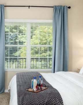 a bedroom with a bed and a window with blue curtains