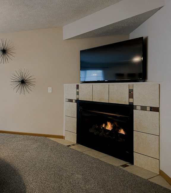 A living room with a fireplace and a television.