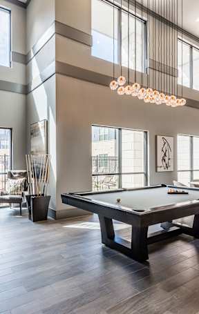 A room with a pool table and a tv.