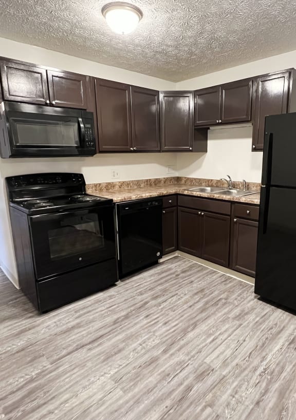 an empty kitchen with black appliances and wooden floors at Quail Meadow Apartments, Ohio, 45240
