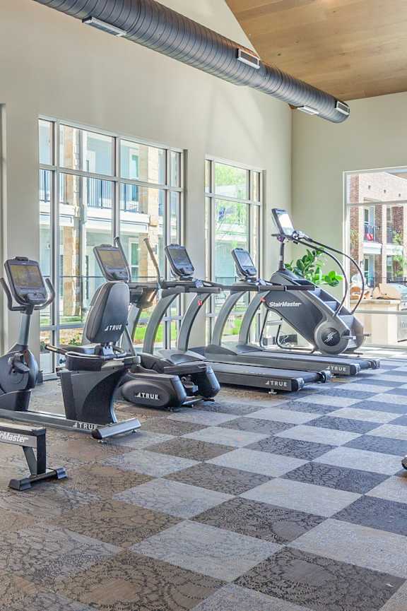 a gym with cardio equipment and weights at the gateway apartments at Magnolia Grove Apartments, Terrell, TX
