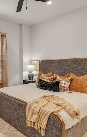 A bedroom with a large bed and a ceiling fan.