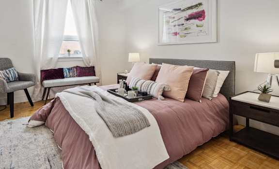 a bedroom with a bed and two chairs and a window