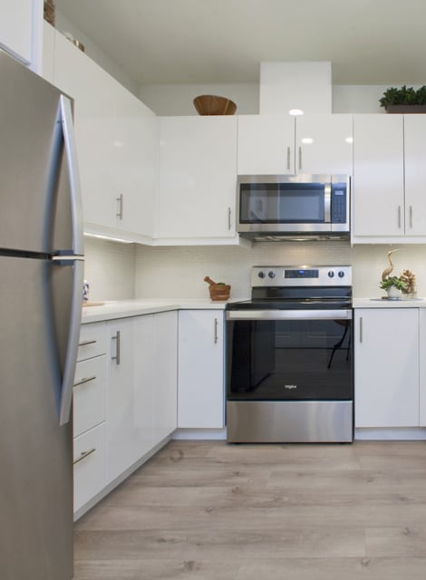 a kitchen with white cabinets and stainless steel appliances