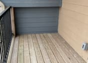Thumbnail 11 of 29 - A sunroom with a wooden wall and a black metal grate.