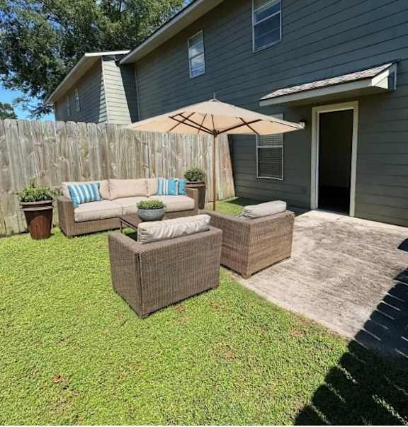 A backyard with a patio set and a wooden fence.