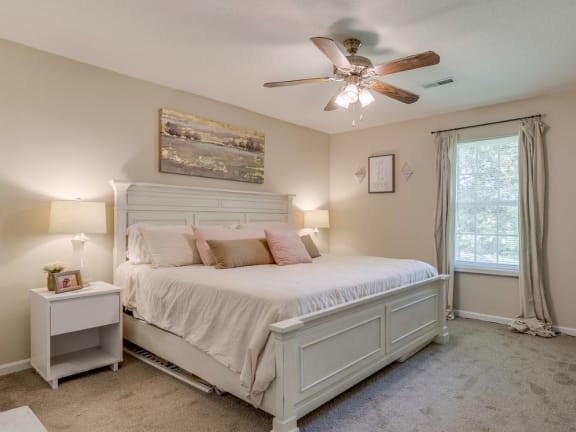 a bedroom with a bed and a ceiling fan