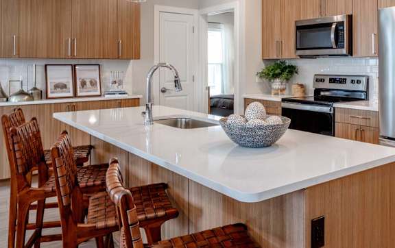A modern kitchen with wooden cabinets and a large island.