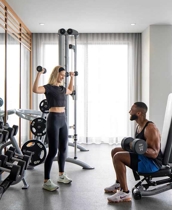A man and woman are working out in a gym with various exercise equipment.at Palma, Doral, 33166