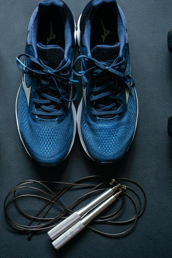 a pair of blue shoes next to dumbbells and weights