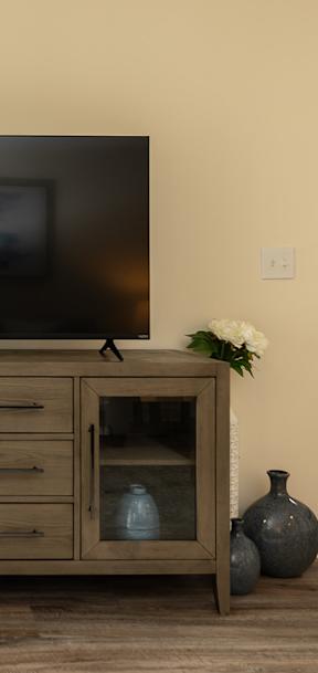 a large painting on a wall above a wooden dresser at The Summit at Owings Mills Apartments, Maryland, 21117