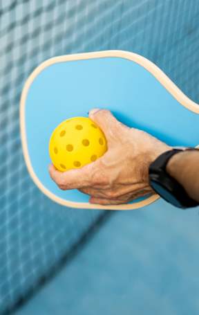 A person holding a tennis racket and ball.