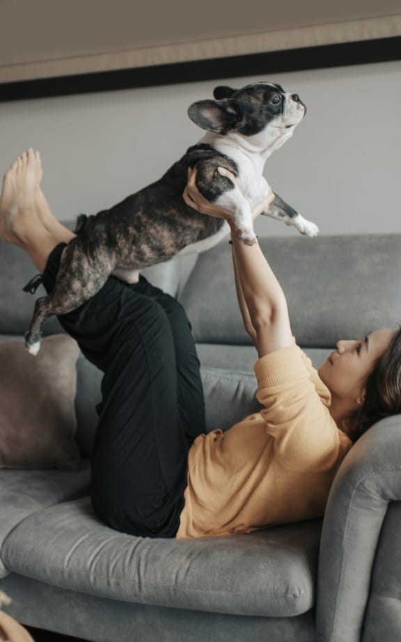 a woman laying on a couch with her dog on her head at Terraces at High Mountain, Huntsville, AL 35811