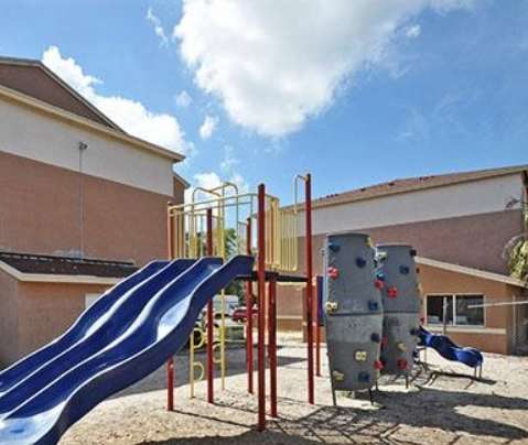 A playground with a blue slide and a climbing wall at Oak Chase II, Tampa, 33612