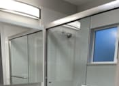 Thumbnail 14 of 19 - A modern bathroom with a glass shower and a toilet.