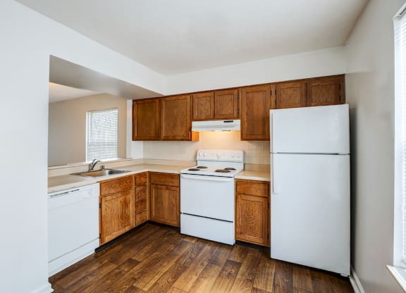 A kitchen with wooden cabinets and white appliances.