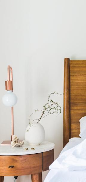A bed with white pillows and a wooden headboard.