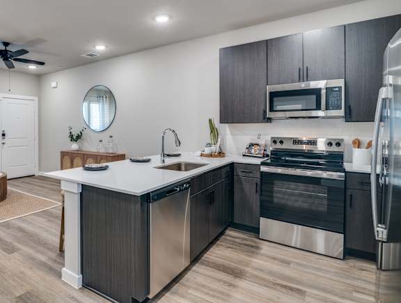 A modern kitchen with a large island and stainless steel appliances.