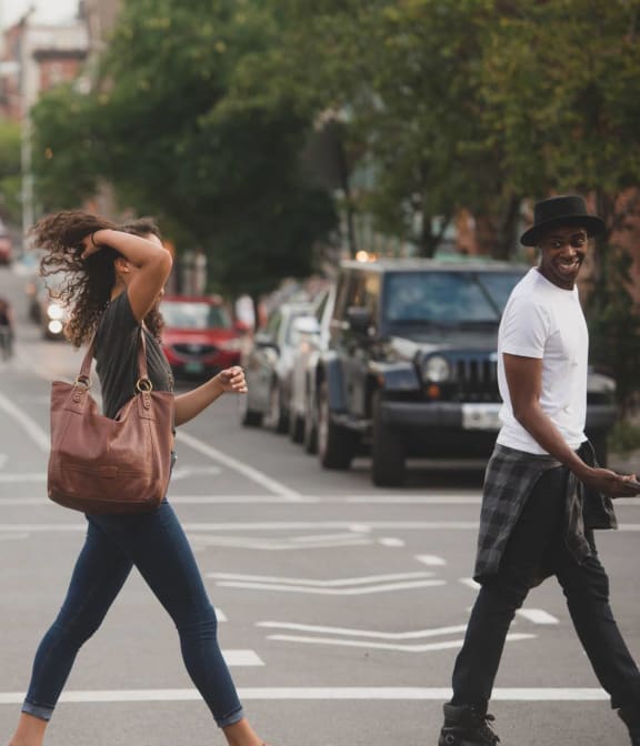 Couple exchanging a laugh while crossing the street