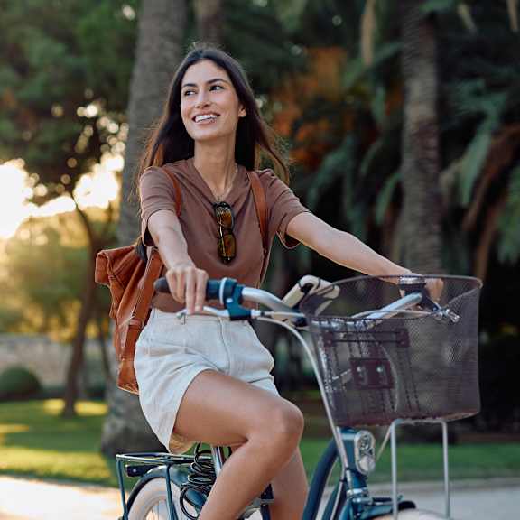 A woman is riding a blue bicycle in a park.