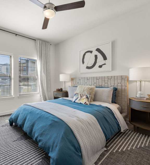 A bedroom with a bed, nightstands, and a ceiling fan. at Bridge at Tech Crossing, Austin, 78753
