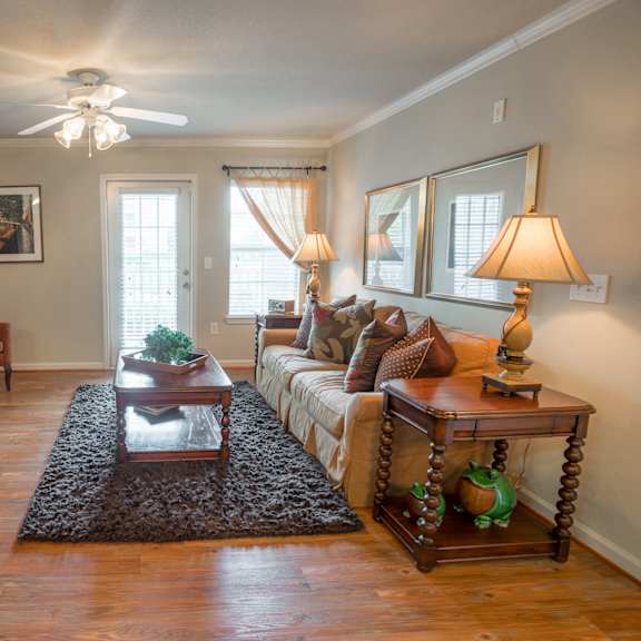 an open concept living room and dining area with a white dining table and rattan chairs