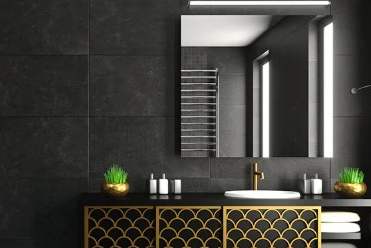 A bathroom with a black and gold color scheme.