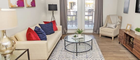 a living room with a ceiling fan and a door leading to a balcony