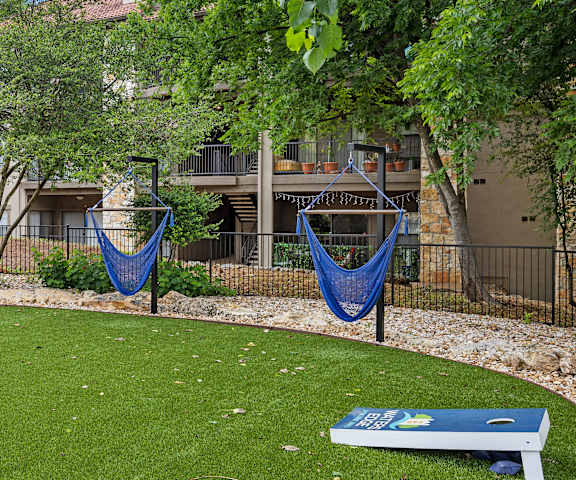 a grassy area with two hammocks and a seesaw at Waters Edge Apartment Homes, Georgetown