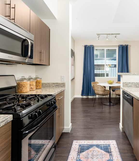 A kitchen with a black stove top oven and a black and white marble counter top.