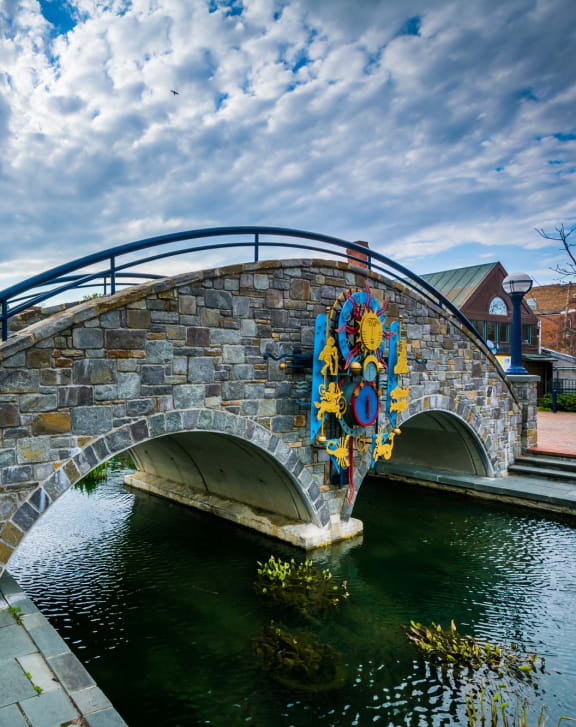 a stone bridge over a river with a street light