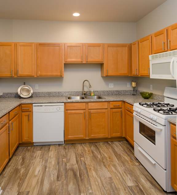 A kitchen with wooden cabinets and white appliances.