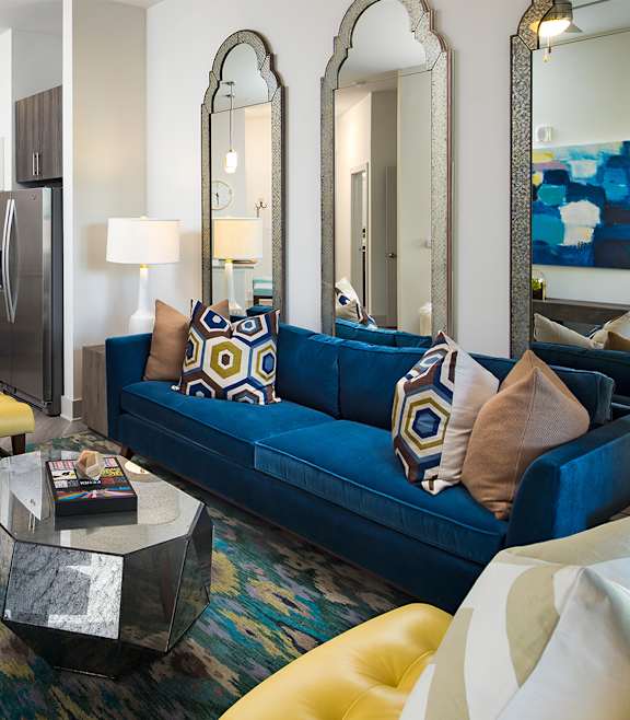 A modern living room with a blue couch and a coffee table at The Flats at Ballantyne Apartments, Charlotte, NC