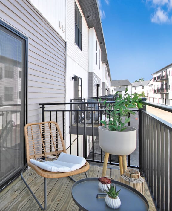 a balcony with a table and chairs and a sliding glass door